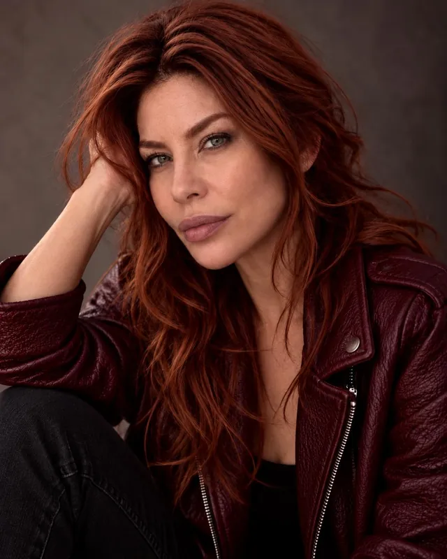 Diana Noris headshot in a burgundy leather jacket