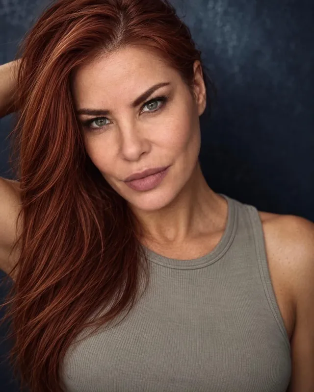 Diana Noris headshot in a grey tank top on a dark blue background